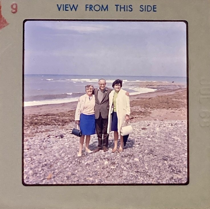 discoloured 120 slide (2¼‑inch square) of a group of adults on a pebble beach – original image ready for professional slide restoration